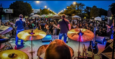 Band performing on the Throwback Music Fest stage at night to a packed crowd